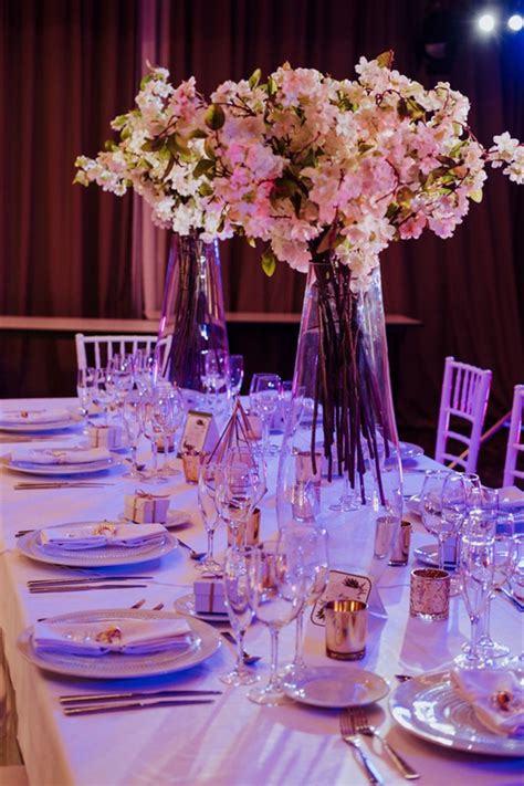 the table is set with flowers in vases