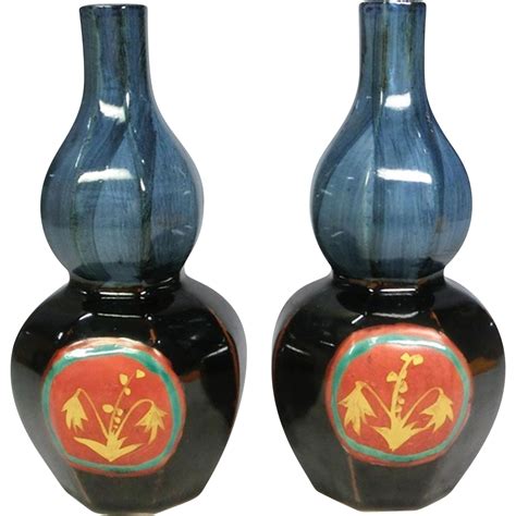 two black vases with red and yellow designs on the bottom one has a ...