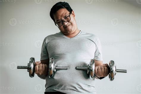 Funny fat man workout with dummbell 19574782 Stock Photo at Vecteezy