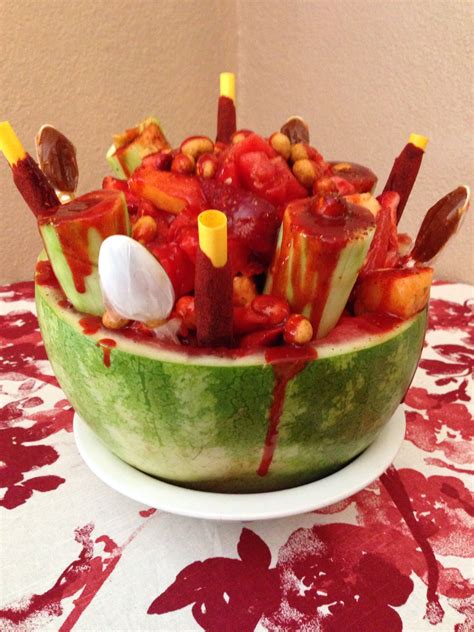 a watermelon bowl filled with candy and candies on top of a table