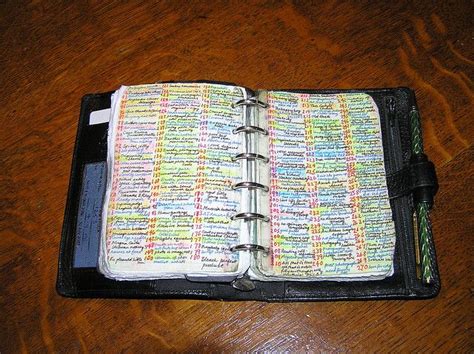 an open bible on top of a wooden table with a pen in the book holder