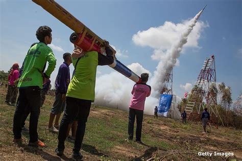 people watch as a rocket is launched into the sky