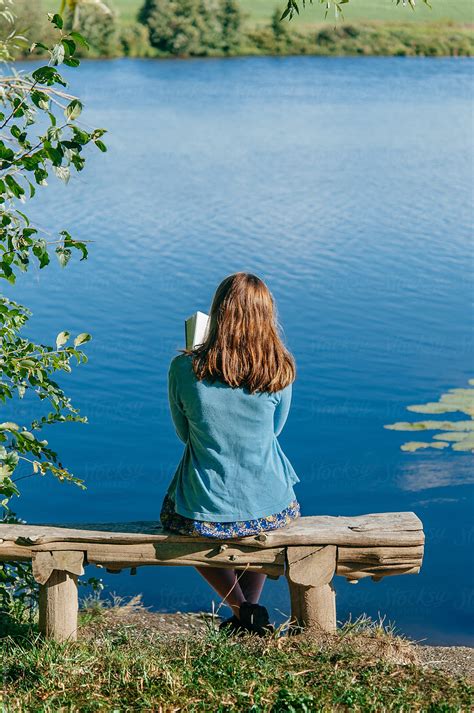 "Teen Girl Reading Book Outside By Pond" by Stocksy Contributor "Deirdre Malfatto" - Stocksy