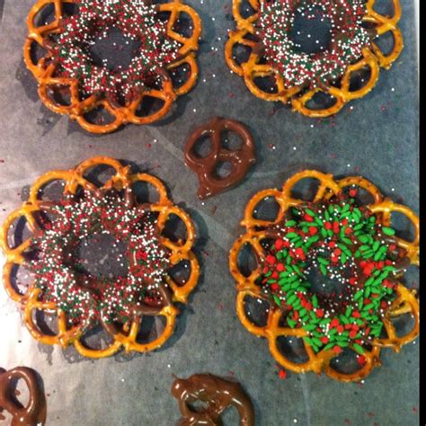 Pretzel wreaths. Dip the bottom edge in melted chocolate and around in a circle. Do an ...