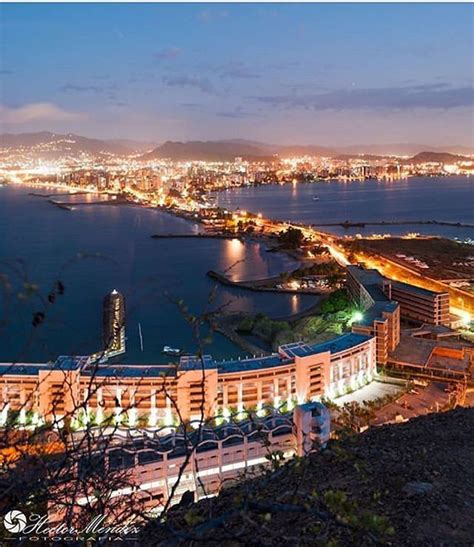 an aerial view of a city at night with lights on the buildings and ...