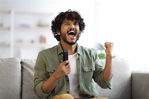 Premium Photo | Indian man cheering at football game on television at home