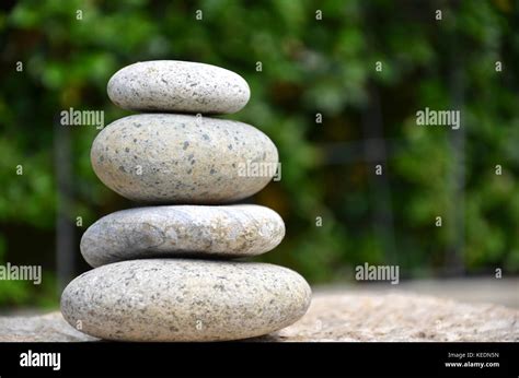 Stack of zen rocks in garden on green background Stock Photo - Alamy