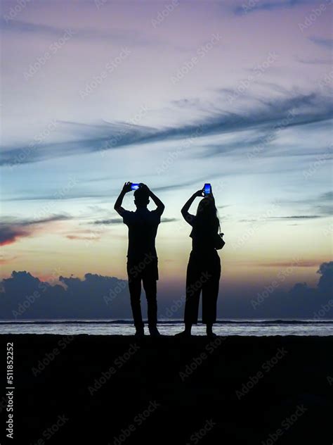 Sunrise silhouette couple taking pictures Stock Photo | Adobe Stock