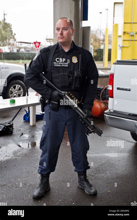 A US Customs and Border Protection officer watches the San Luis border ...