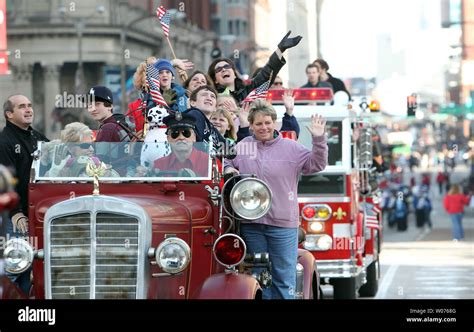 Parade participants wave from a firetruck during the annual ...