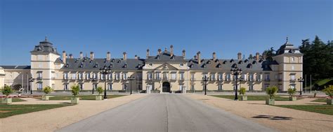 a large building with lots of windows on top of it's sides and a driveway leading to the front ...