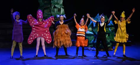 a group of people standing on top of a stage with their hands in the air