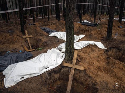 Photos: Grim exhumations continue at mass grave in Ukraine | Russia ...