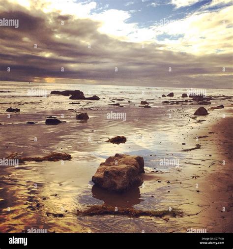 Rock on beach at sunset Stock Photo - Alamy