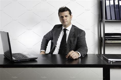 Businessman sitting at desk | High-Quality Business Images ~ Creative Market