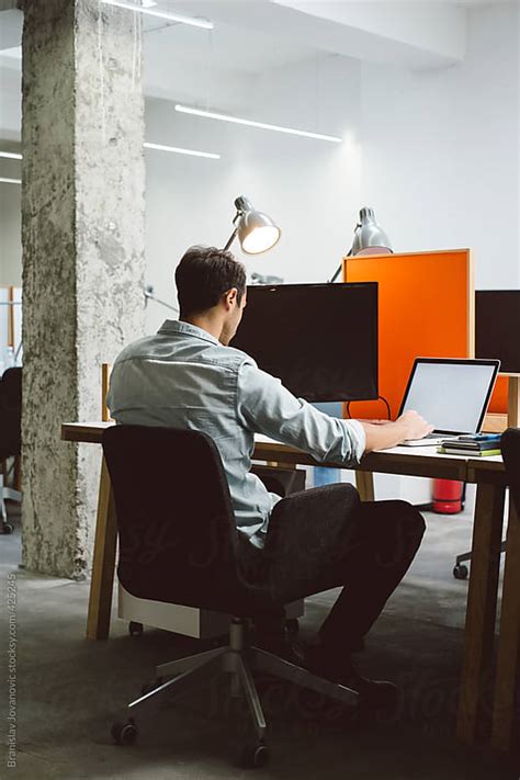 Man sitting at his desk and working on a laptop by Branislav Jovanović - Business, Office ...