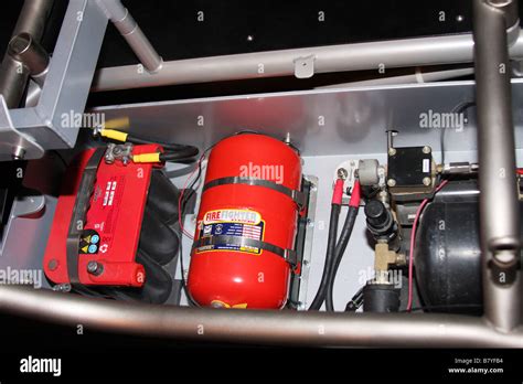 Semi automatic fire extinguisher system permanently installed in a racing car under a floor ...