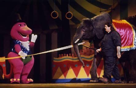 an elephant is being walked by a man in front of two circus elephants ...