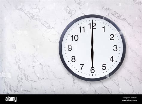 Wall clock show six o'clock on white marble texture. Office clock show ...