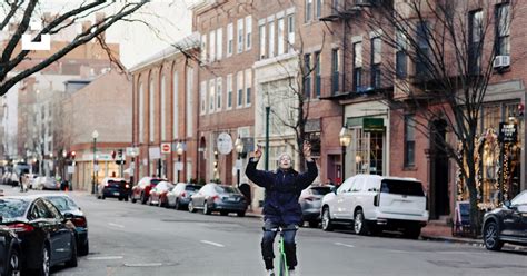 A person riding a bike on a city street photo – Free Neighborhood Image ...