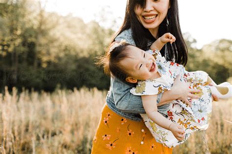 "Asian Mom And Daughter Snuggling, Cuddling, And Playing Outdoors" by ...