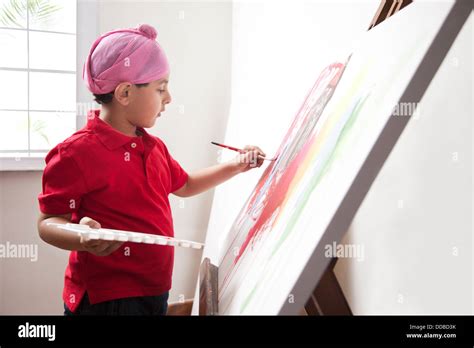 Cute little boy painting on artist's canvas with paintbrush Stock Photo - Alamy