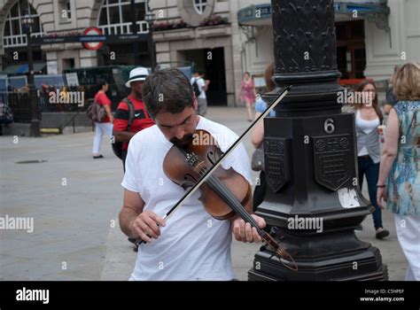 Busker playing the violin at Piccadilly Circus London Stock Photo - Alamy