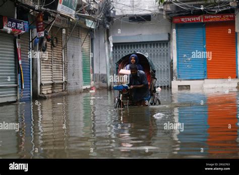 DHAKA, BANGLADESH- AUGUST 7, 2023: A man pulls his rickshaw through ...