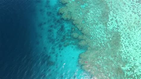 A birds eye view of the sea and coral reef underwater. Shot shows a boat on the ocean. Aerial ...