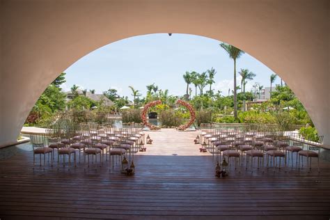 an outdoor ceremony set up with pink chairs