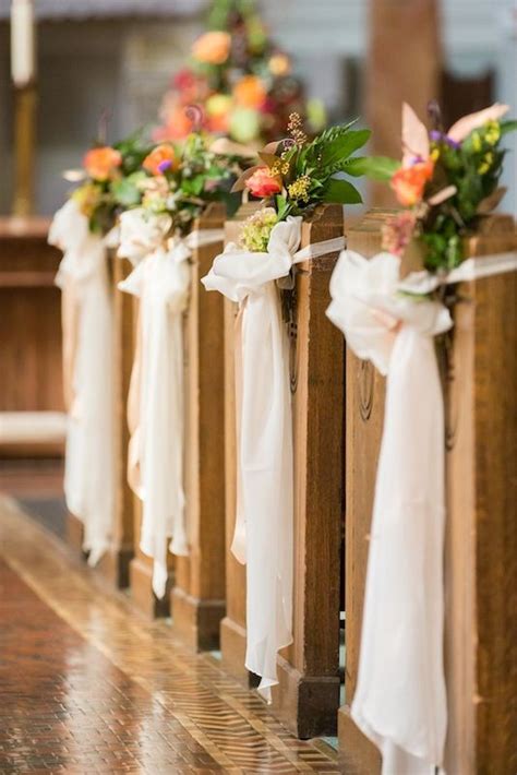 row of wooden pews decorated with flowers and ribbons