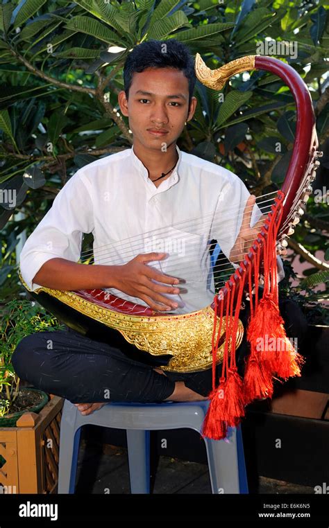 Burmese man playing the Saung Gauk, Burmese harp or arched harp ...