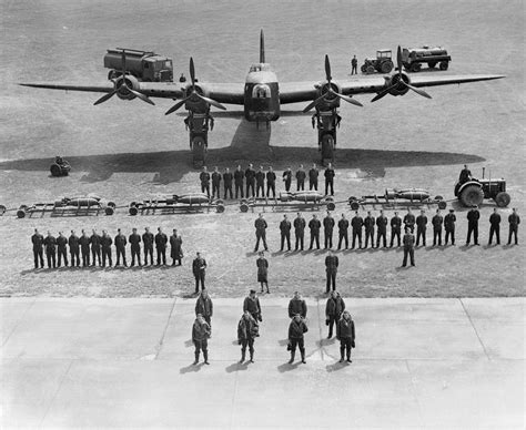 RAF Bomber Command aircrew and ground-crew line up in front of a Short Stirling bomber to ...