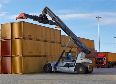 Forklift hoisting cargo container — Stock Photo © lagereek #6448411