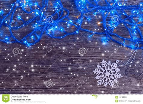 Garland with Blue Lights and a White Snowflake on a Wooden Background ...