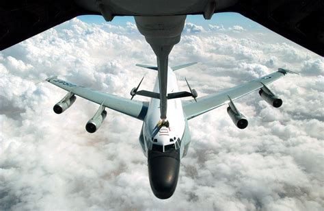 A US Air Force (USAF) RC-135 Rivet Joint aircraft refuels from the extended refueling arm of a ...