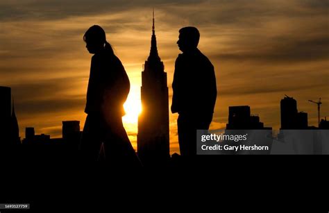 The sun rises behind the Empire State Building in New York City as ...