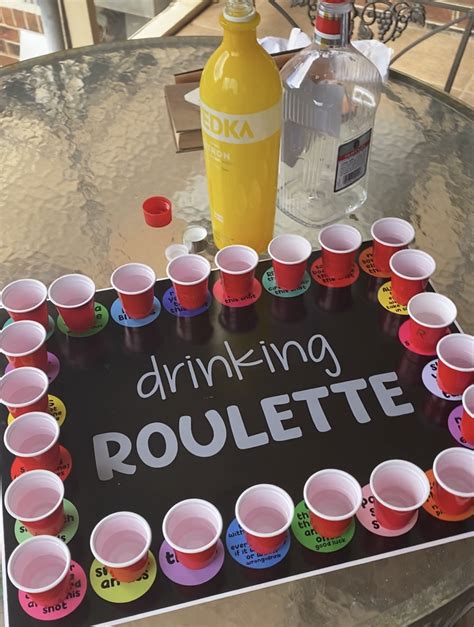 a table topped with lots of cups and a sign that says drinking roulette