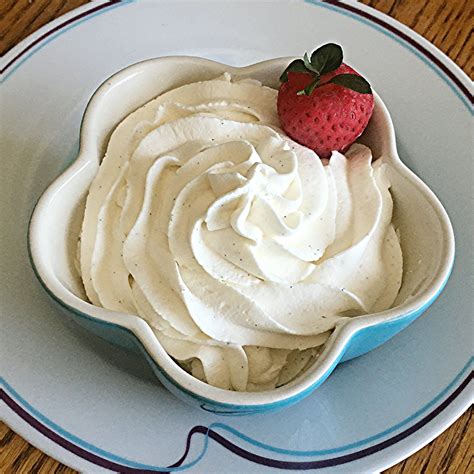 a bowl filled with whipped cream and a strawberry on top