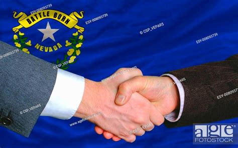 two businessmen shaking hands after good business investment agreement in front US state flag of ...