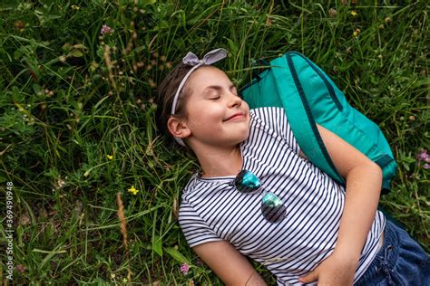 Smiling little girl lying with her eyes closed on grass Stock Photo ...