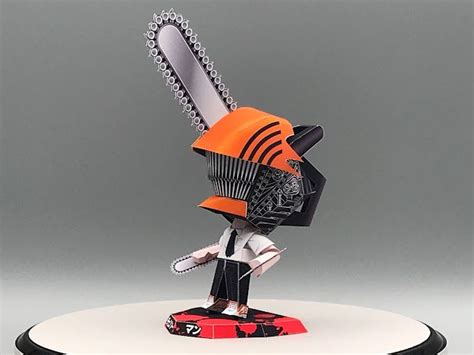 a figurine holding a chainsaw on top of a white and black base