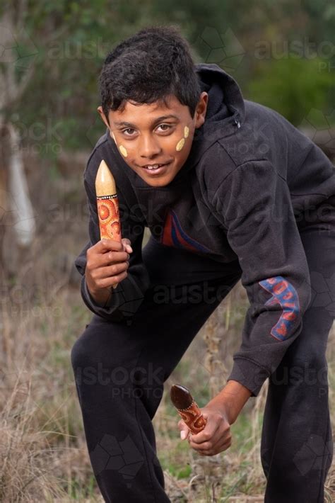 Image of Young Aboriginal Boy with clapstick instrument - Austockphoto