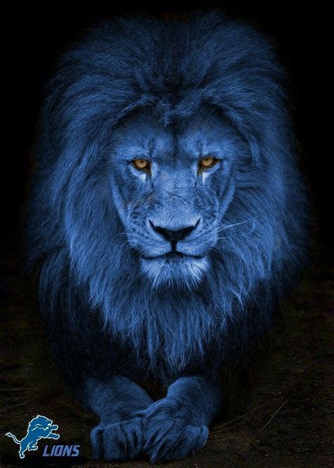 a blue lion sitting in the dark looking at the camera