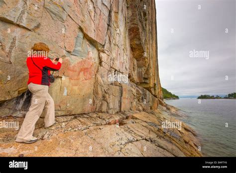 Tourist viewing the ancient pictographs on Agawa Rock, Agawa Rock ...