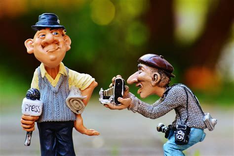 Man Taking Photo Of Man Standing Beside Him Holding Press Microphone Statue · Free Stock Photo