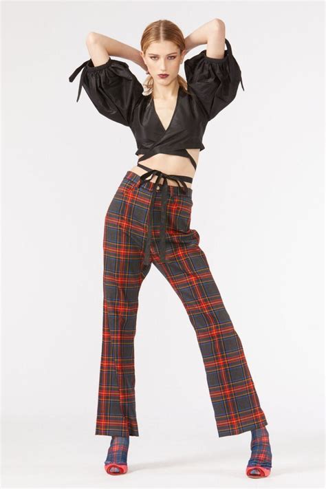 a woman in plaid pants and crop top posing for the camera with her ...