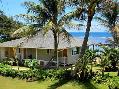 a house with palm trees and the ocean in the background