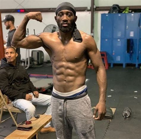 a shirtless man flexing his muscles in a gym with other men sitting on ...