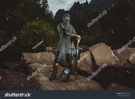 Medieval Knight Stands On Rocks On The Background Of Mountains Stock ...